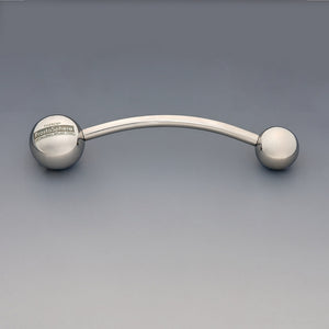ProstaSphere Theros®: Dispositivo per massaggio ergonomico per la prostata e il pavimento pelvico, composto da un’asta leggermente curva con una sfera da 45 mm come impugnatura con logo su un lato e una sfera di massaggio intercambiabile da 36 mm sull’altro lato. Vista frontale.