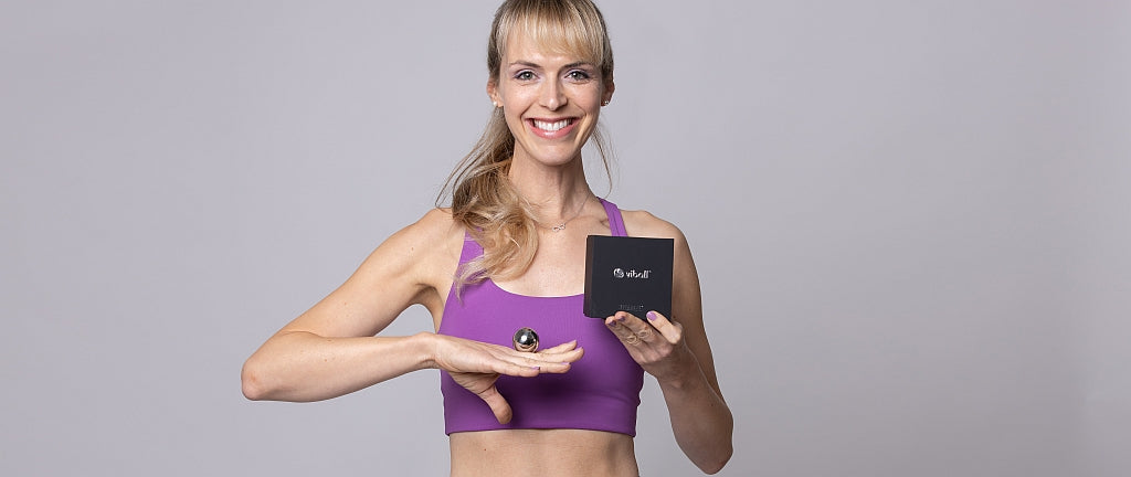 Physiotrainerin Renate von Samoya Fitness im Gymnastik-Dress demonstriert Beckenbodenübungen und hält eine Viball medizinische Liebeskugel ins Bild.