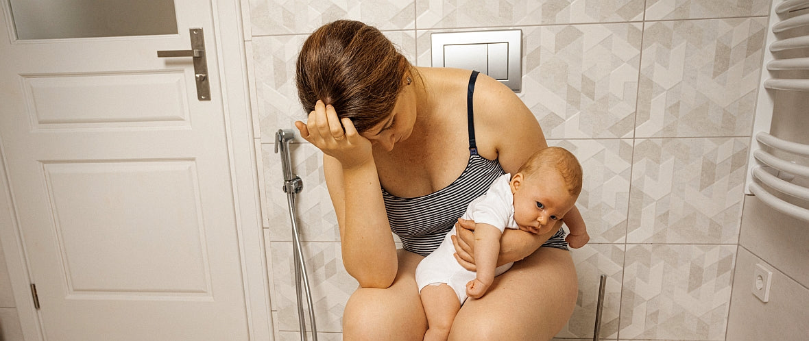 Haemorrhoiden nach Geburt und Schwangerschaft: Frau hält Baby im Arm