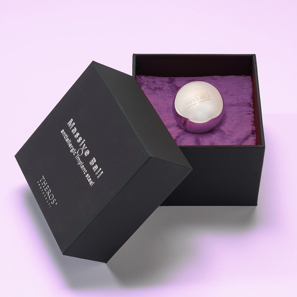 Theros® Massive Ball MB40 – 40 mm large solid ball made of anti-allergenic stainless steel for women and men for pelvic floor training in horizontal positions or for prostate stimulation in a black box on dark purple velvet.