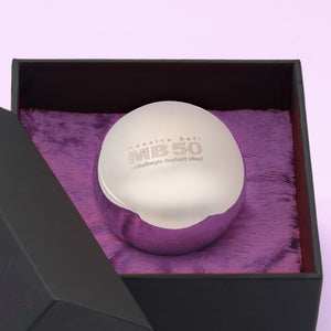 Theros® Massive Ball MB50 – esfera maciza de 50 mm de acero inoxidable antialérgico para mujeres y hombres para el entrenamiento del suelo pélvico en posiciones horizontales o para la estimulación de la próstata en una caja negra sobre terciopelo violeta oscuro, vista detallada.