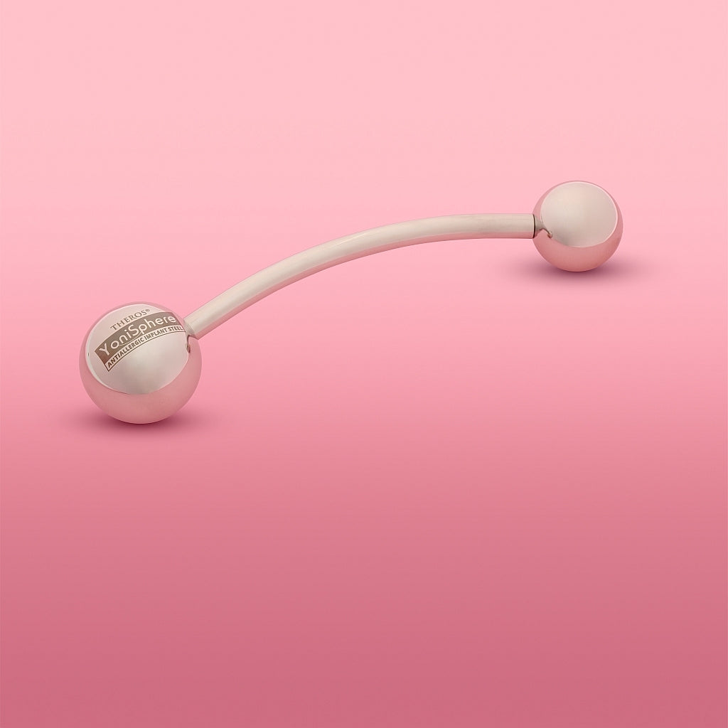 YoniSphere Theros® YS36: Dispositivo de masaje ergonómico para el suelo pélvico y la vagina para la relajación física y mental, compuesto por una varilla ligeramente curvada con una bola de 45 mm como mango con logotipo en un lado y una bola de masaje intercambiable de tamaño 36 mm en el otro lado. Vista desde la izquierda.
