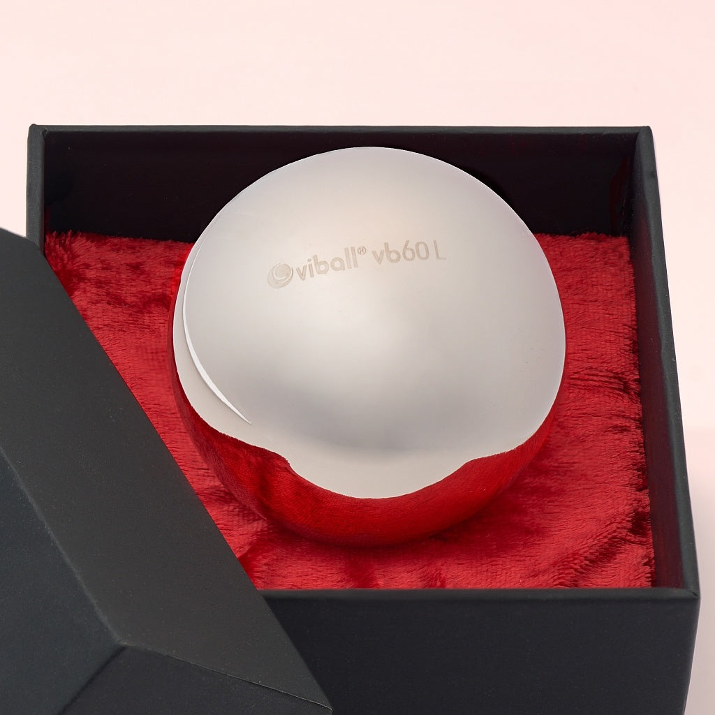 Gros plan d’une Viball VB60 Light boule de Geisha médicale de 60 mm en acier inoxydable anti-allergique pour femmes et hommes dans une boîte noire sur velours rouge.
