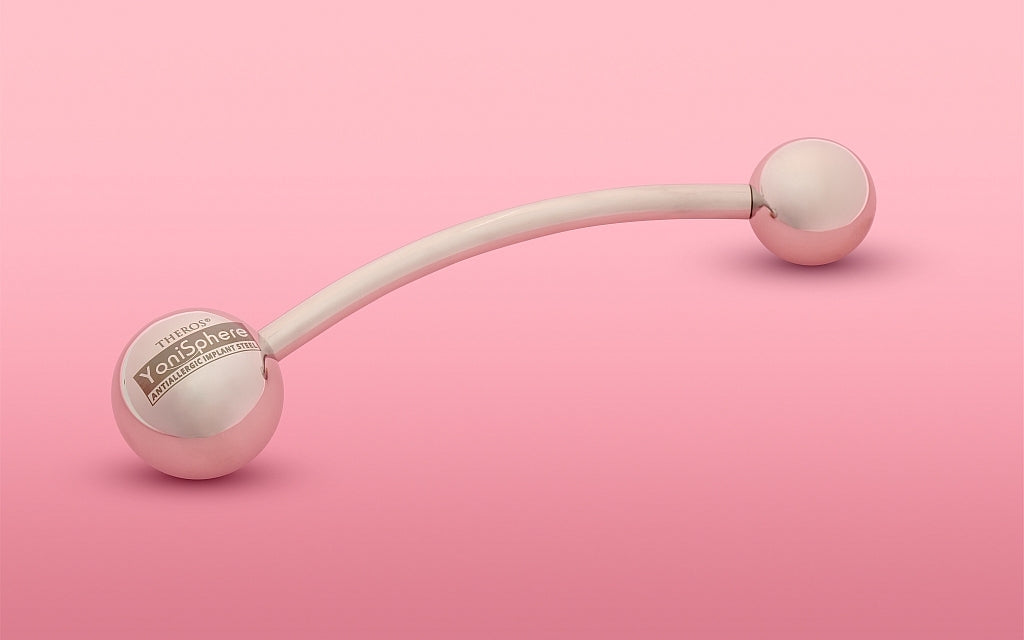 Appareil de massage Theros® YoniSphere pour le périnée et le vagin, destiné à la détente profonde, outil en cas de rectocèle et contre les hémorroïdes, composé d’une tige légèrement courbée avec une sphère de 45 mm servant de poignée avec logo d’un côté et une sphère de massage interchangeable de l’autre côté.