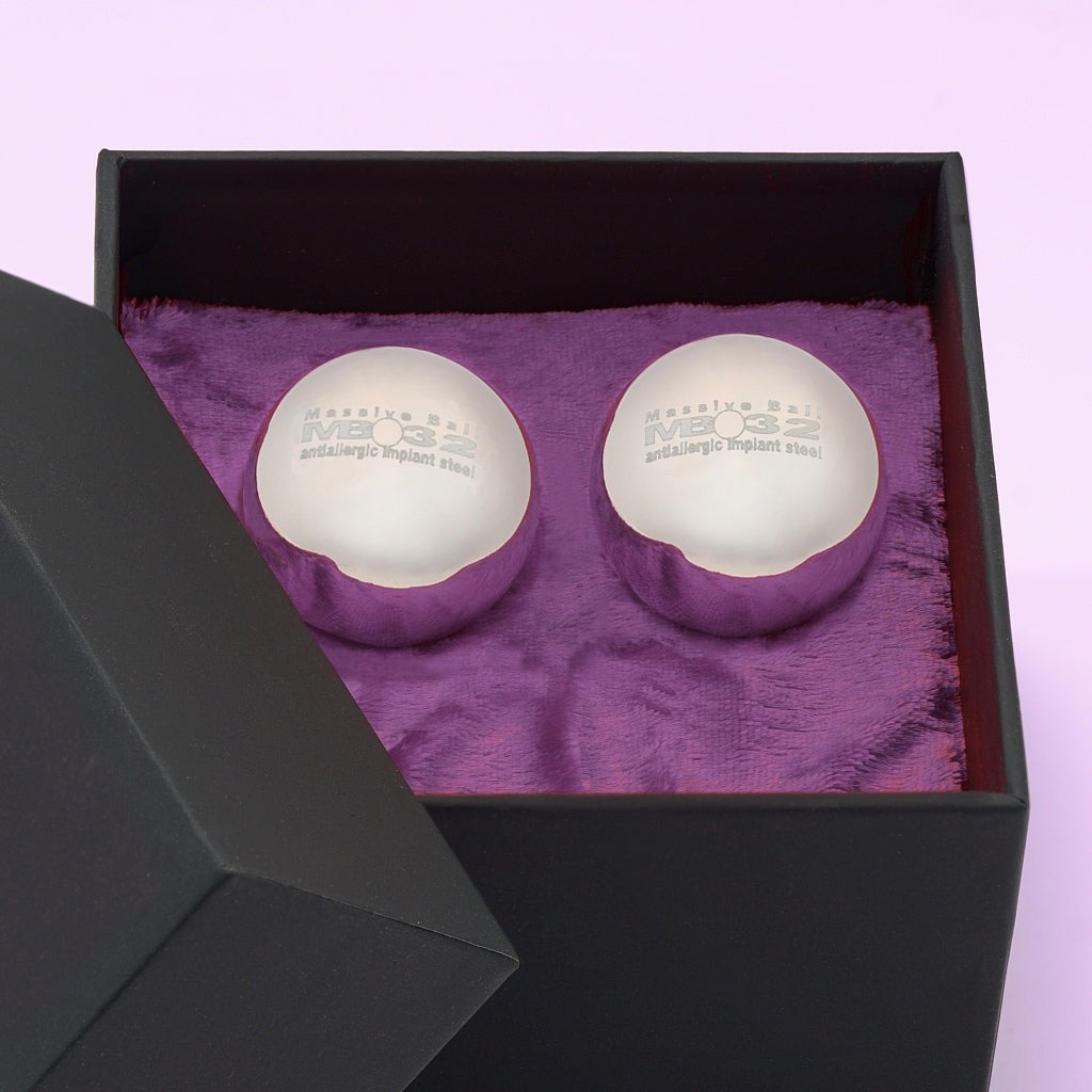 Theros® Massive Ball MB32-2 – Une paire de boules massives de 32 mm en acier inoxydable anti-allergique pour femmes et hommes pour l’entraînement du périnée en positions horizontales ou pour la stimulation de la prostate dans une boîte noire sur du velours violet foncé. Vue détaillée.