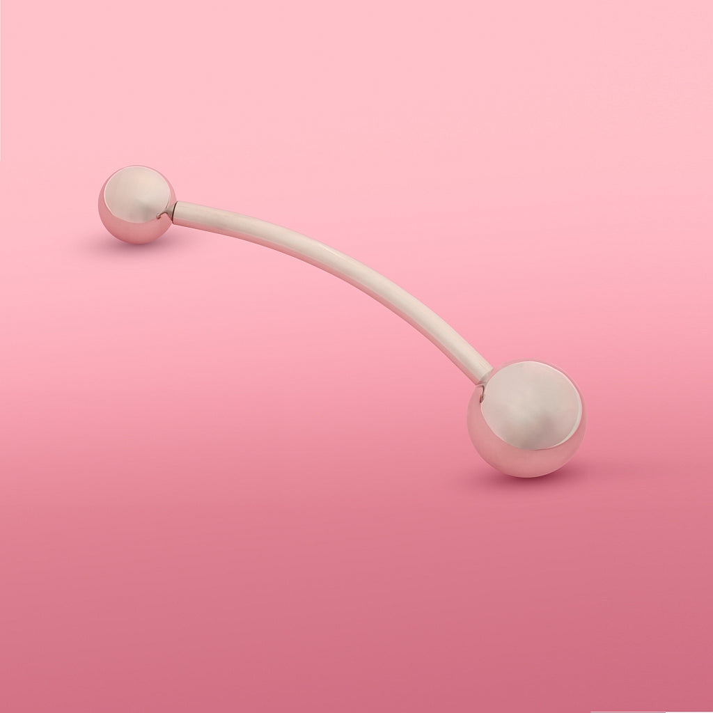 Theros(R) Yonisphere 32: Innovatives Hilfsmittel aus poliertem edelstahl für Dammmasssage, Beckenbodenmassage, Probleme in der Vagina wie Geburtsverletzungen, Endometriose und Hämorrhoiden bei Frauen bestehend aus aufschraubbaren Massagekugeln in verschiedenen Größen an einer gebogenen Stange. Rosa Hintergrund.