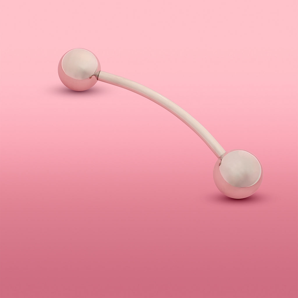 Theros YoniSphere: Innovatives Hilfsmittel aus antiallergenem Implantatstahl zur effizienten Massage von Vagina und Beckenboden und zur Reponierung von Hämorrhoiden, bestehend aus einer gebogenen Stange mit zwei aufgeschraubten Kugeln, eine als Handgriff und eine Massagekugel in 40  mm. Ansicht: diagonal mit Massagekugel 40 mm links.